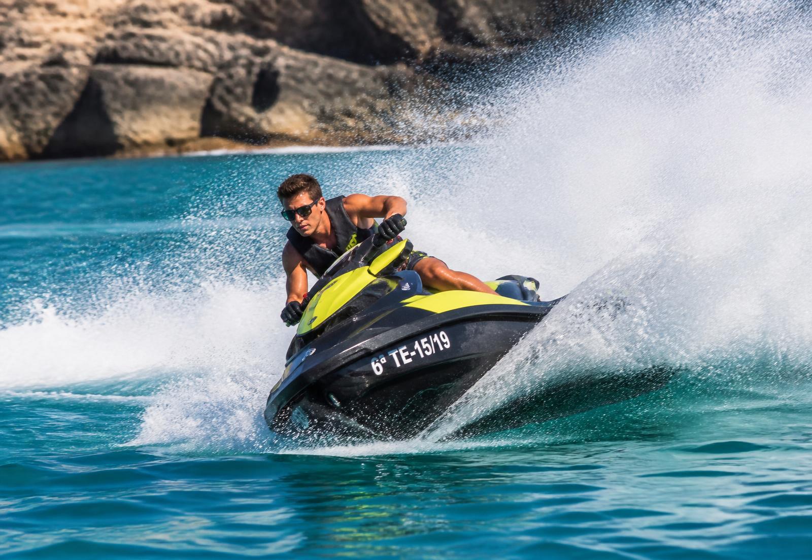 Rider carving a turn on a jet ski with heavy water spray